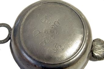 Skål av tenn med handtag i form av snäcka och godronnerad ring.