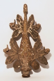 Ett snidat ornament i form av en blomma, blå- och vitmålat samt förgyllt med två hål för fastsättning. Ett genombrutet, snidat ornament, målat grönt med spår av förgyllning.