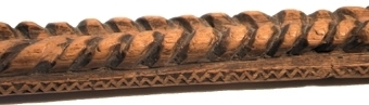 Fyrsidigt alnmått, snidat på översidan med två parallella repstavsornament och med kilsnittsbårder vid kanterna. Mässingstift och skåror som skala.