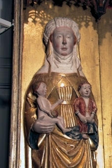 Altarskåp. Skåpets motiv är Den heliga släkten med de tre Mariorna i halvskulptur. 

I mitten sitter en krönt jungfru Maria på tron med Jesusbarnet på knät. till vänster står Maria Kleofas, med sönerna Judas Taddeus, Barnabas, Simon och Jacob den yngre. Till höger står Maria Salome, med sönerna Johannes och jacob den äldre. I medaljonger under sockeln återges kvinnornas respektive män: Josef, Kleofas och Salome. 

Mittskulpturen är krönt och frontalt sittande på tron med grön kudde. Manteln är förgylld med blå insida över en förgylld tunika. Kronan har tinnar och fyra blomformade applikationer. Karnationen är ljus med röda kindrosor och håret brunt. Skorna röda och marksockeln är grön. Barnet sitter på högerknät med ett röd-grönt äpple i handen och är vänt åt sidan. Klädedräkten är försilvrad. 

Den vänstra skulpturen är frontalt stående med ett barn på varje arm och två vid fötterna. Manteln är förgylld med blå insida över förgylld tunika med hermelinmönstrad kant nertill. Vit turban över vitt dok och vitt halslinning. Skon är röd. Marksockeln är grön. Ett barn är naket med äpple i handen och ett barn har röd mantel. Två barn har förgyllda klädedräkter med röda böcker.

Den högra skulpturen är frontalt stående med ett barn på varje arm. Manteln är förgylld med blå insida över en förgylld tunika med hermelinmönstrad kant. Skon är röd. Doket är vitt och halslinningen är vit med ett rött mönster. Ett barn har förgylld tunika med bälte och en uppslagen bok i knät. Det andra barnet har försilvrad tunika och en röd bok.

Skåpets ramverk har en profilerad framkant med bladmetall och blå bemålning. Insidan är röd och utsidan mörkröd liksom sockelns översida. Ryggstycket har en mittnisch, är förgyllt och har glorior ovanför skulpturerna och nertill en röd kant. Masverket är genombrutet och består av krabbor, kölbågar, hängkonsoller och strävpelare som bildar tre nischer över skulpturerna. Gallerverket med tre medaljonger förställer tre frontala halvfigurer skurna i relief med namnvimplar mot en röd bakgrund. Flygeldörrar saknas.