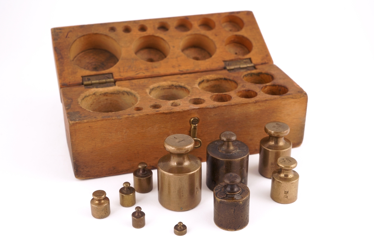 Trekassett inneholdende 10 stk. lodd. Loddene angitt i kg og g.
Loddsamlingen inni er ikke komplett. Seks av loddene er antagelig originale. Fire av loddene har antagelig ikke opprinnelig tilhørt denne esken da de har et annet utseende/annen utforming.