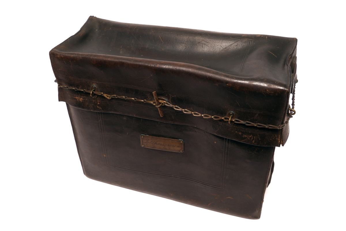 Veske av lær med 9 messingbøyler og to messinglenker for låseanordning. Låsepinne av tre. (Denne ligger i vesken)