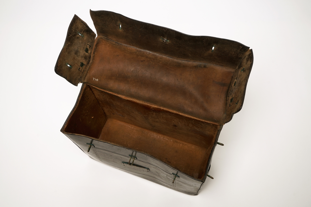 Veske av lær med 9 messingbøyler og to messinglenker for låseanordning. Låsepinne av tre. (Denne ligger i vesken)