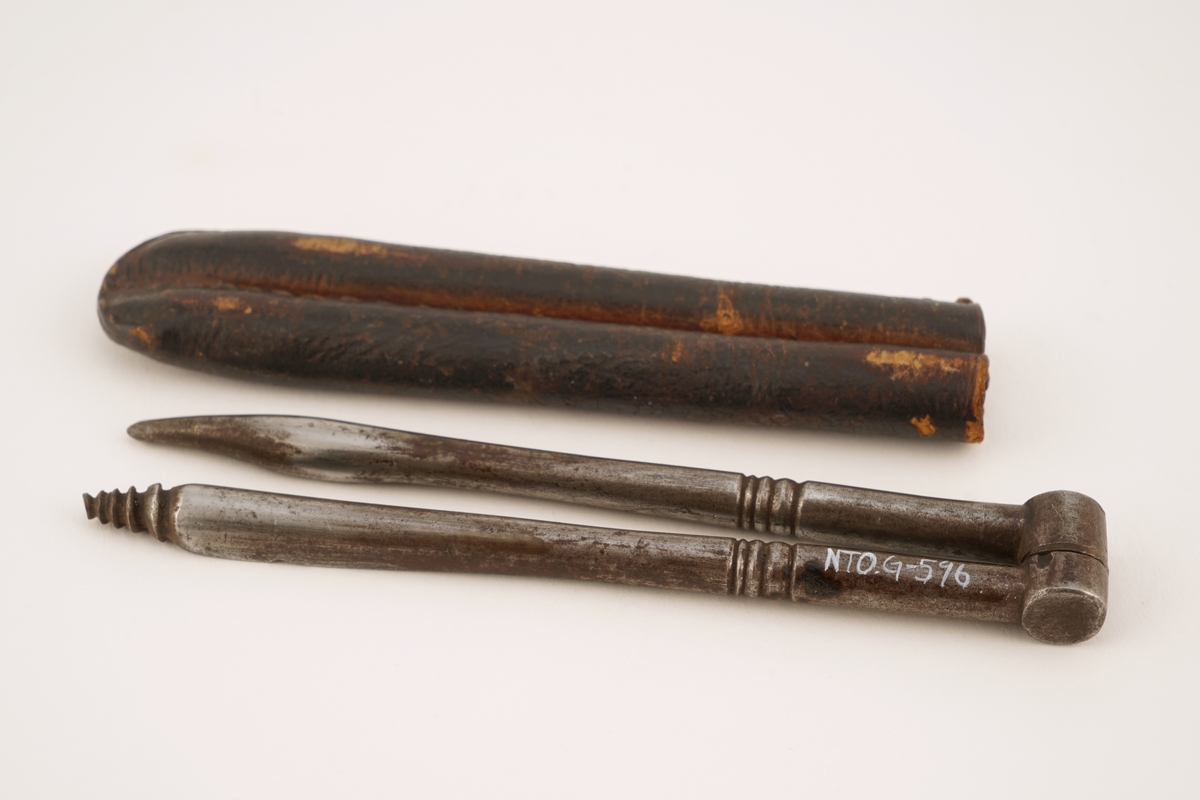 To sammenhengende bor av metall, den ene bor, den andre skålformet syl. Lagt i etui av lær.