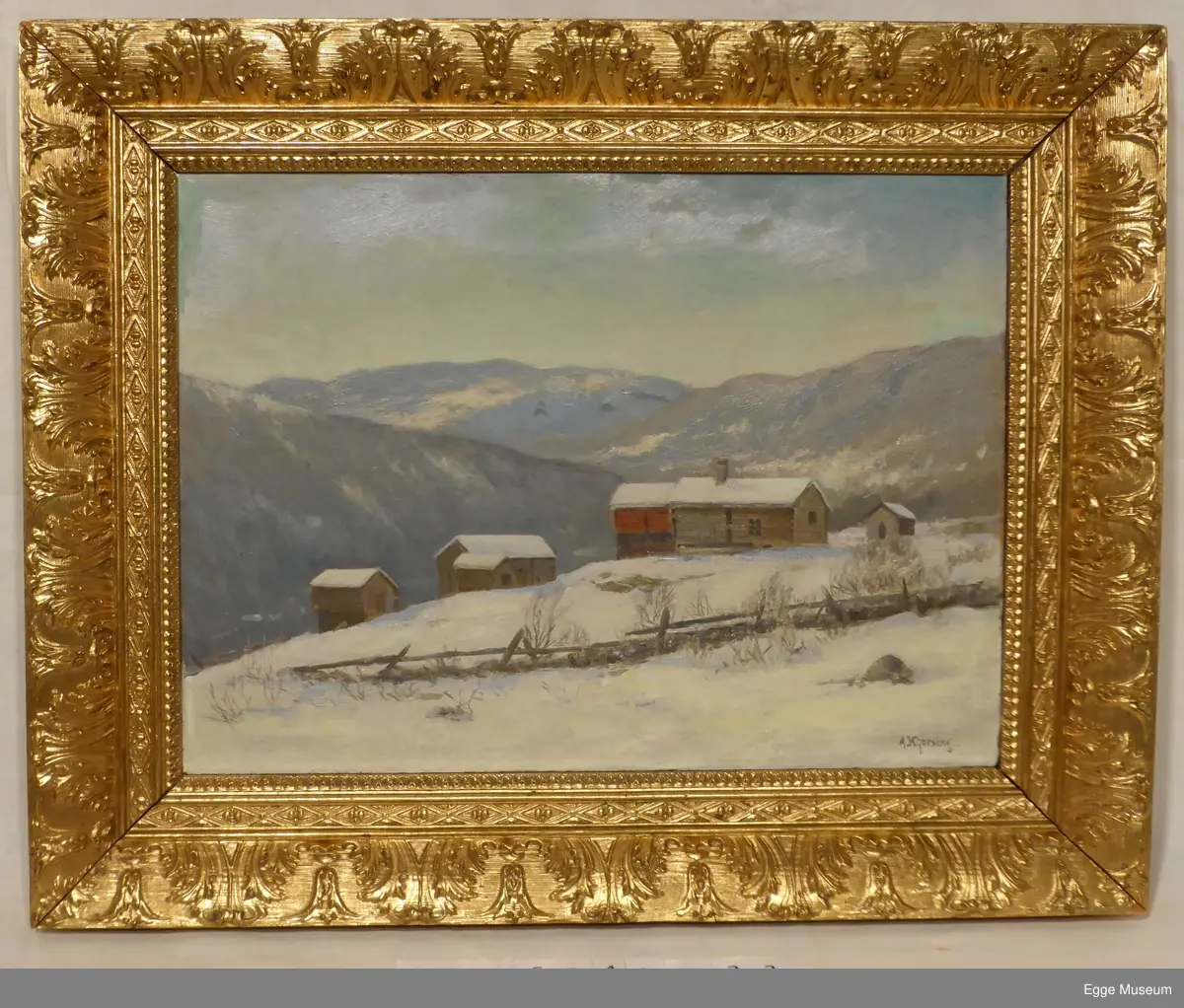 Fjellandskap på vinterstid. En gård med seks laftede tømmerbygninger og deler av et gjerde av stein og trestokker ses i forgrunnen, på brinken av en dal. Husene ser ut til å være umalte, med unntak av en rødmalt bygning som trolig er en låve. Bakken i forgrunnen er dekket av snø, noen steiner, busker og kratt stikker opp. Dalsidene og toppene i bakgrunnen er dekket av en del vegetasjon. Himmelen er lys blå og klar.