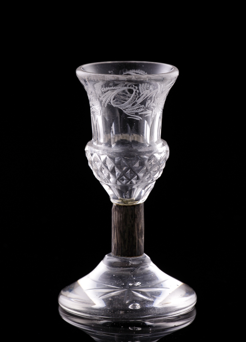 Brännvinsglas med metallben. 
Slipat, med graverad bladdekor.