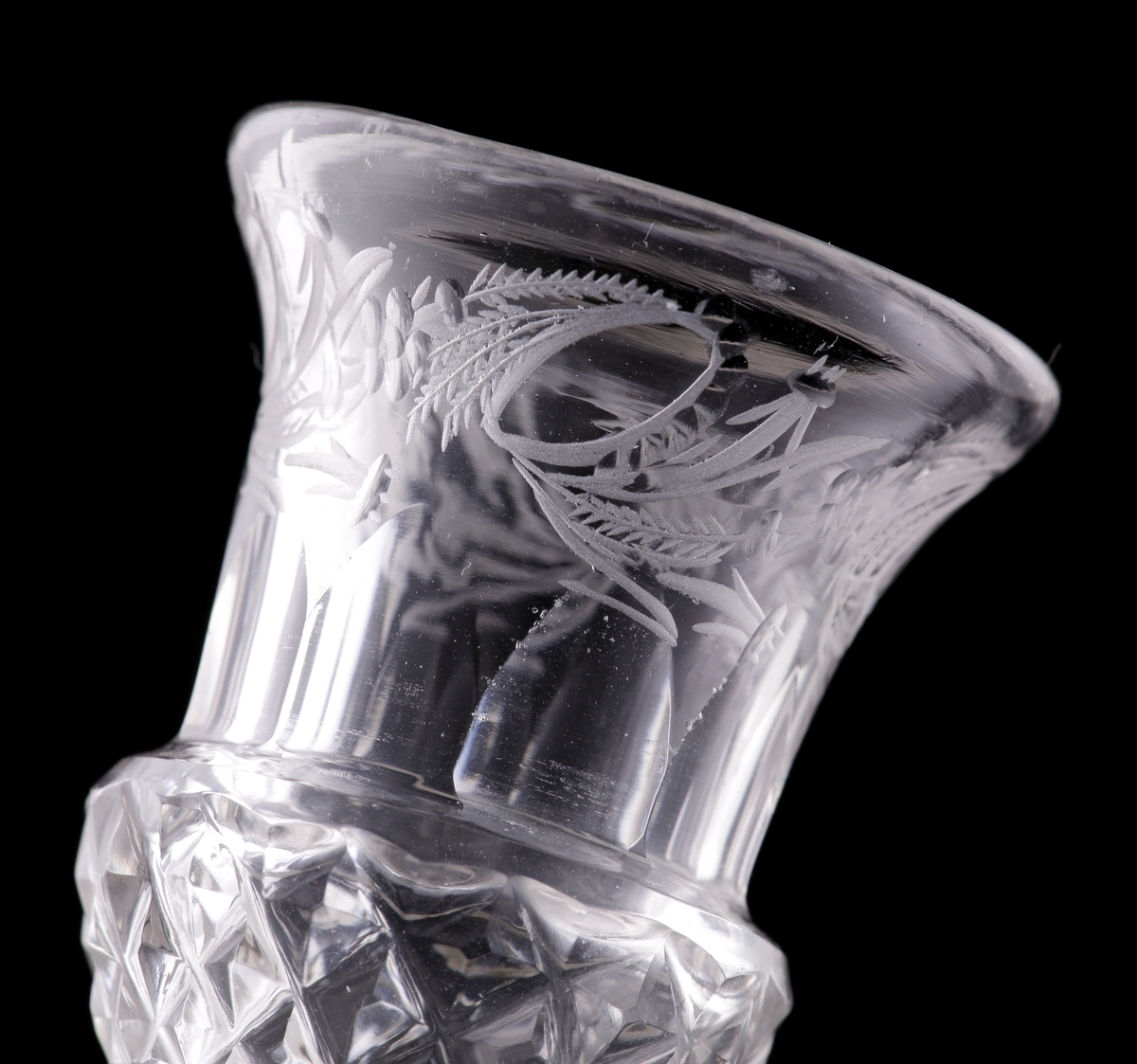 Brännvinsglas med metallben. 
Slipat, med graverad bladdekor.