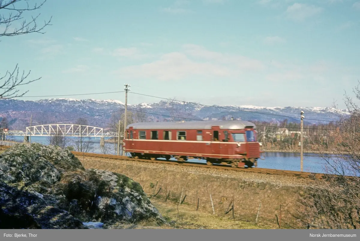 Motorvognene BM 87 04 i persontog 3005 ved Sirnes - med den gamle jernbanebrua på sporet mot Tronviken i bakgrunnen