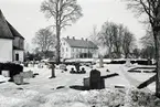 Absiden på Madesjö kyrka och prästgården i fonden.