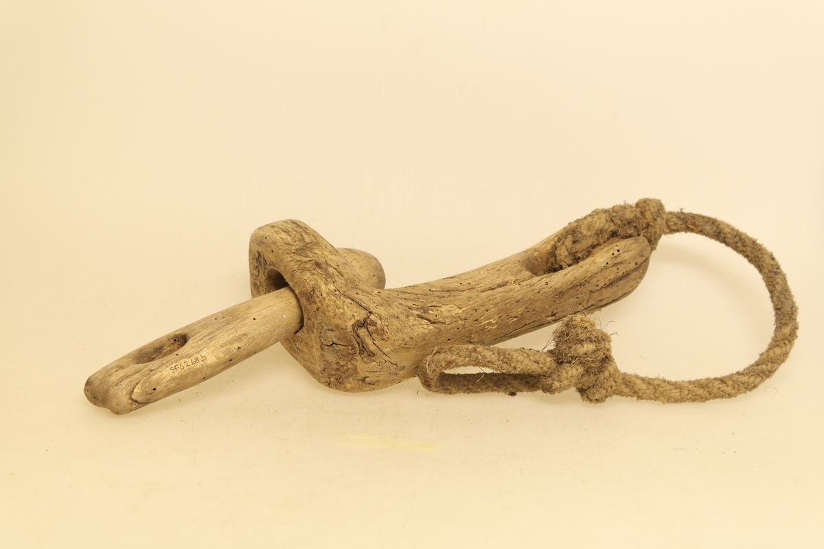 Veggband/Lekkjend i skåret eik. To ledd er skåret ut av samme trestykke, slik at begge kan svinge rundt. Utsparing i hver ende av leddene. Det er bundet et rep i det ene leddet.