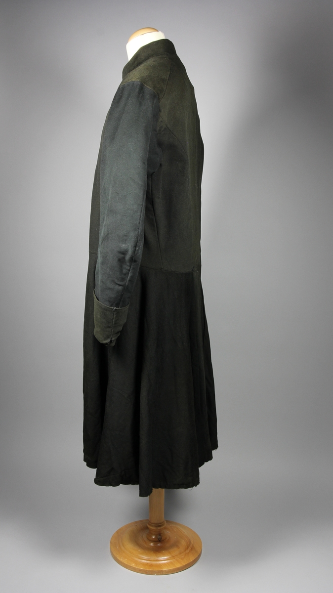 Rock av svart tuskaftsvävt yllekläde. Rocken har en 3,5 cm hög ståkrage. Ärmarna har två längsgående sömmar och 11 cm breda uppslag. Ryggstycket är sammanfogat av fyra våder. Vid axlarna är en trekantig kil infälld på var sida. Troligen en besparing. I höfthöjd har rocken en mittsöm som löper hela vägen runt. Skörten är skurna med stort omfång och rundade. I mitten bak är båda skörten förlängda med en remsa som överlappar på höger sida i ett sprund. Nederkanten har på flera ställen infälda stycken, troligen för att utnyttja tyget maximalt eller som lagningar. Rocken stängs fram med 9 par hyskor och hakar av grov mässingstråd.

Fodret är sytt av minst tre olika tyger. Överst ett grövre grårandigt linnetyg med två infällda innerfickor. Ärmarna är fodrade med oblekt linne och har vaddering av bomullsvadd. Nederst i båda ärmsluten finns rester av blåfärgade linneremsor. Kanske ett tidigare fodertyg eller ett mellanlägg. Rockens nedre foderdel är av ett tunt linne eller bomullstyg med tryckt mönster i brunt på ljusbrun botten. Möjligen är den övre delen av fodret yngre än den nedre. Slitaget på den övre är mindre än på de nedre. Hela rocken är handsydd, men det förekommer lagningar och bättringar med raksöm från symaskin. Det finns flera mindre och några större hål samt sömmar som släppt.