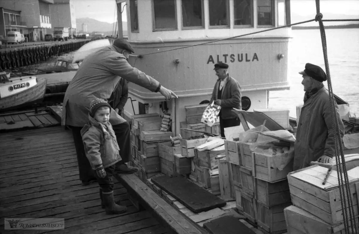 "november 1965".Båten Altsula ved Torgkaia i Molde..F-74-NK, er bygd i 1919 og høyrte heime i Honningsvåg. Båten er bygd i 1919 og høyrte heime i Honningsvåg. Her har båten vore i Sogn eller Hardanger og kjøpt eple for vidaresal, kassevis og mindre ved Torgkaia i Molde.