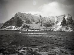 Landskap med bygninger og to seilende nordlandsbåter