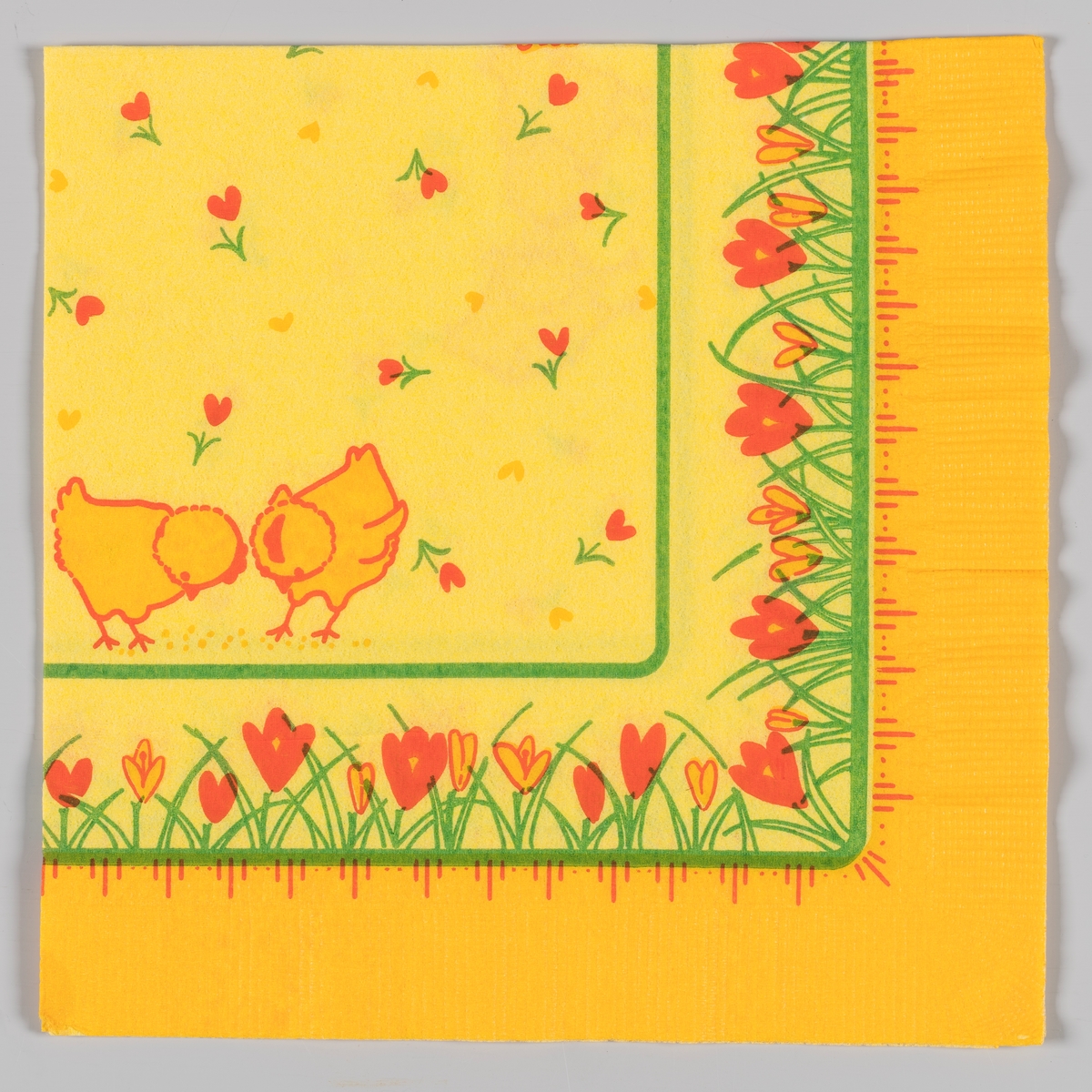 To påskekyllinger, gule hjerter og røde hjerteformede blomster. Grønne kantstriper. Gule og røde krokus langs kanten. Stripe og prikkemønster.