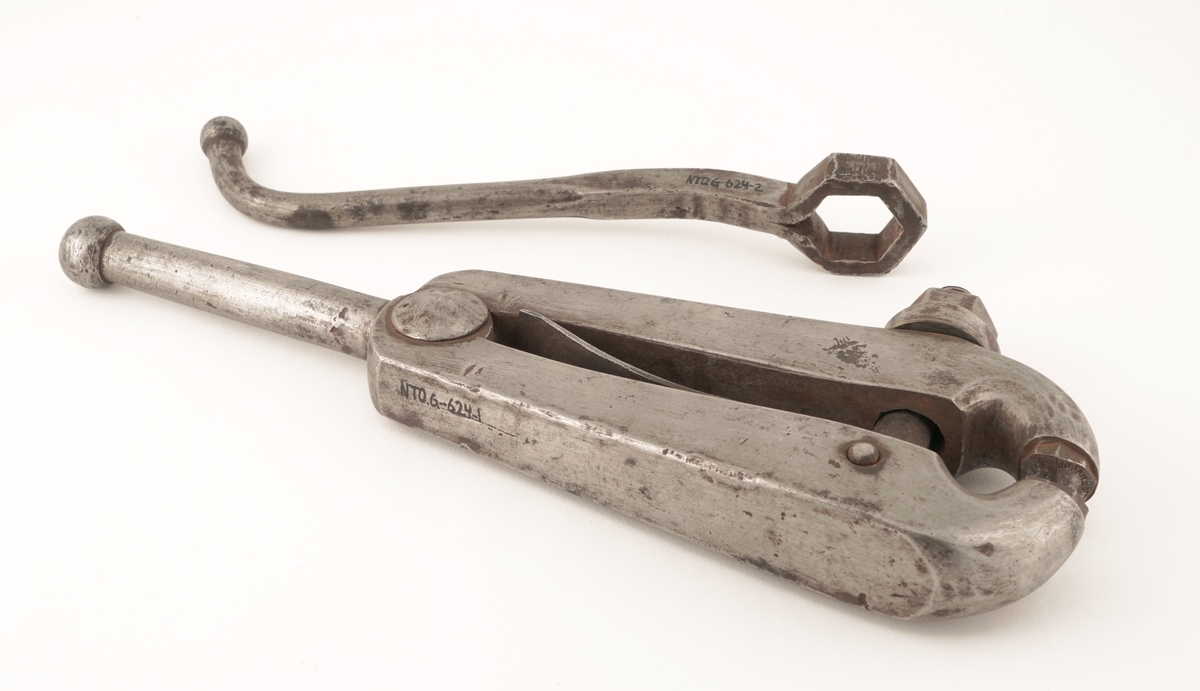 Plomberingstang av metall med skrumekanisme og nøkkel