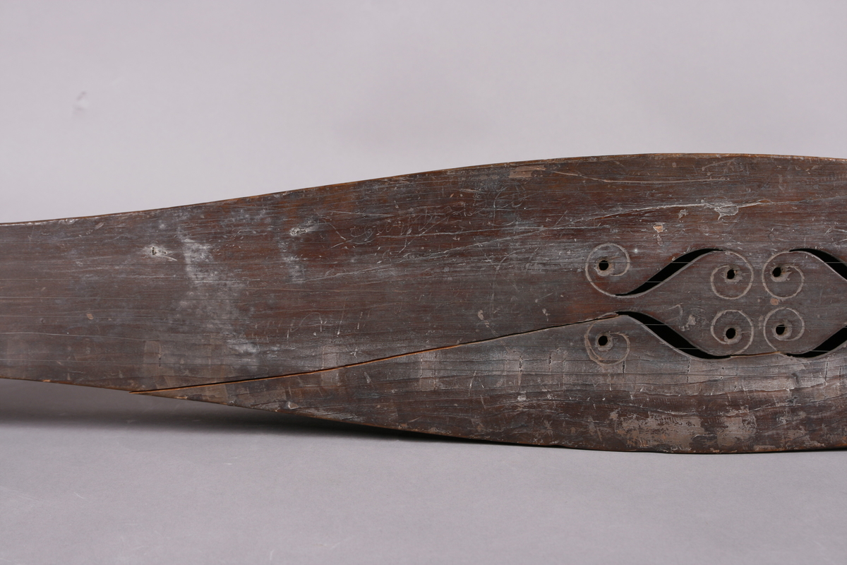 Korpus sammensatt av 4 bord, bunn og lokk limt på sidene. Lokk og bunnn i nåltre, sarger i løvtre. Hode og skruekasse i ett stykke - av løvtre. Hode i form av enkel snekke, 8 stemmeskruer. Sidene buket (Valdrestype), øvre fot mangler. 3 lydhull: 1 mindre grovt ovalt ved anslag (ant. etter kvist, (JV)), samt to par s-formet hull parvis speilvent (lager en hjerteform!).
Strengene festet i stifter like bak stol. Høyre sadel og forstykke festet til korpus med trenagler. Hele instrumentet er beiset mørk brunt. Skala på melodistrengen. Alle noter og pyramider mangler. Spor i lokket etter notene, ca 16 stk. Spor etter to strengeleder - gir korteste strenge ytterst.