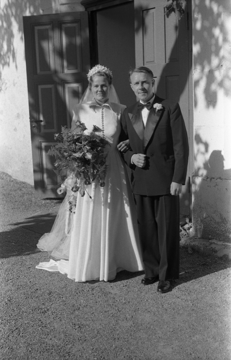 Brudeparet Else Rustad og Edvard Narum fotografert foran inngangen til Hoff kirke. Serie på 11 portretter, noen i helfigur, andre i halvfigur.