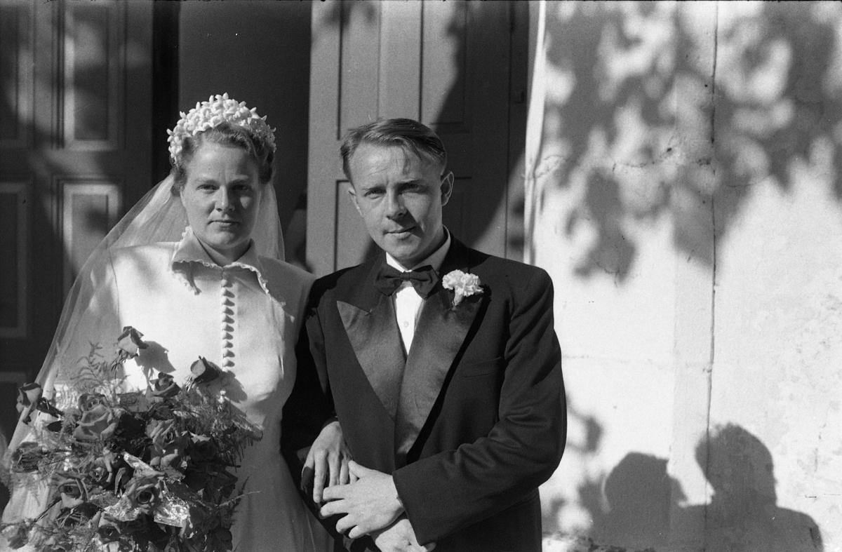 Brudeparet Else Rustad og Edvard Narum fotografert foran inngangen til Hoff kirke. Serie på 11 portretter, noen i helfigur, andre i halvfigur.