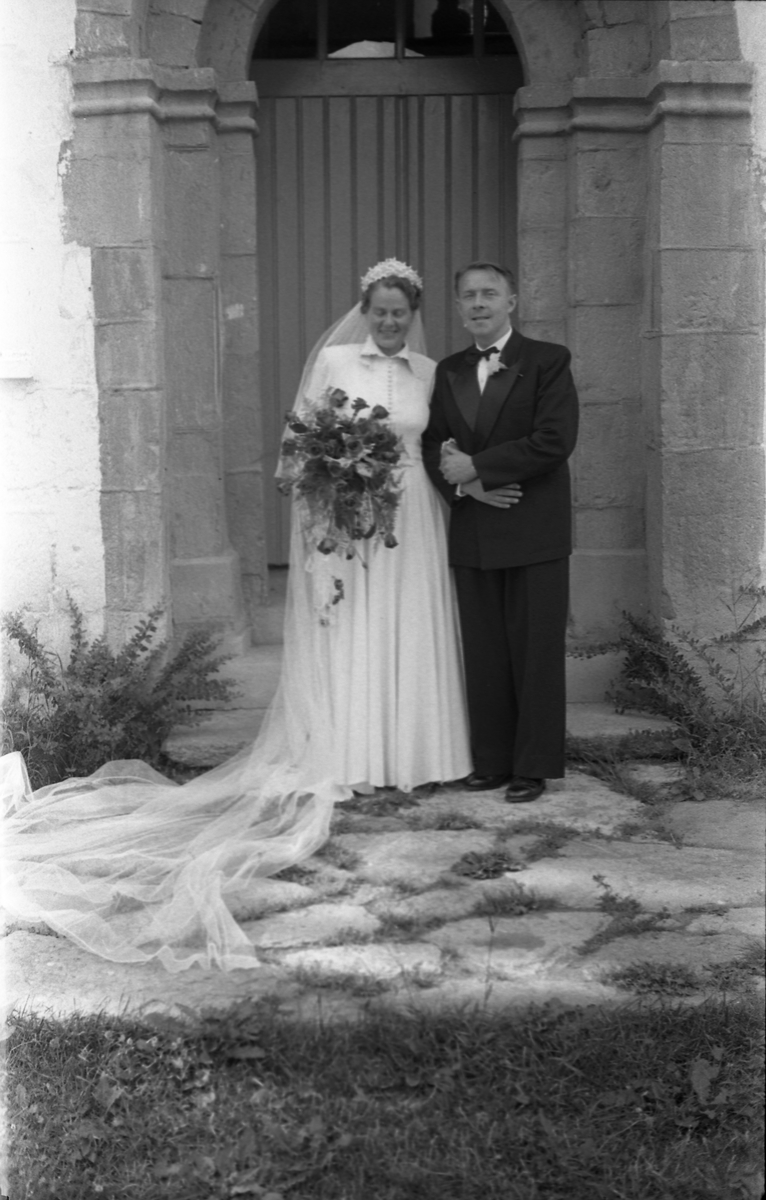 Brudeparet Else Rustad og Edvard Narum fotografert foran inngangen til Hoff kirke. Serie på 11 portretter, noen i helfigur, andre i halvfigur.