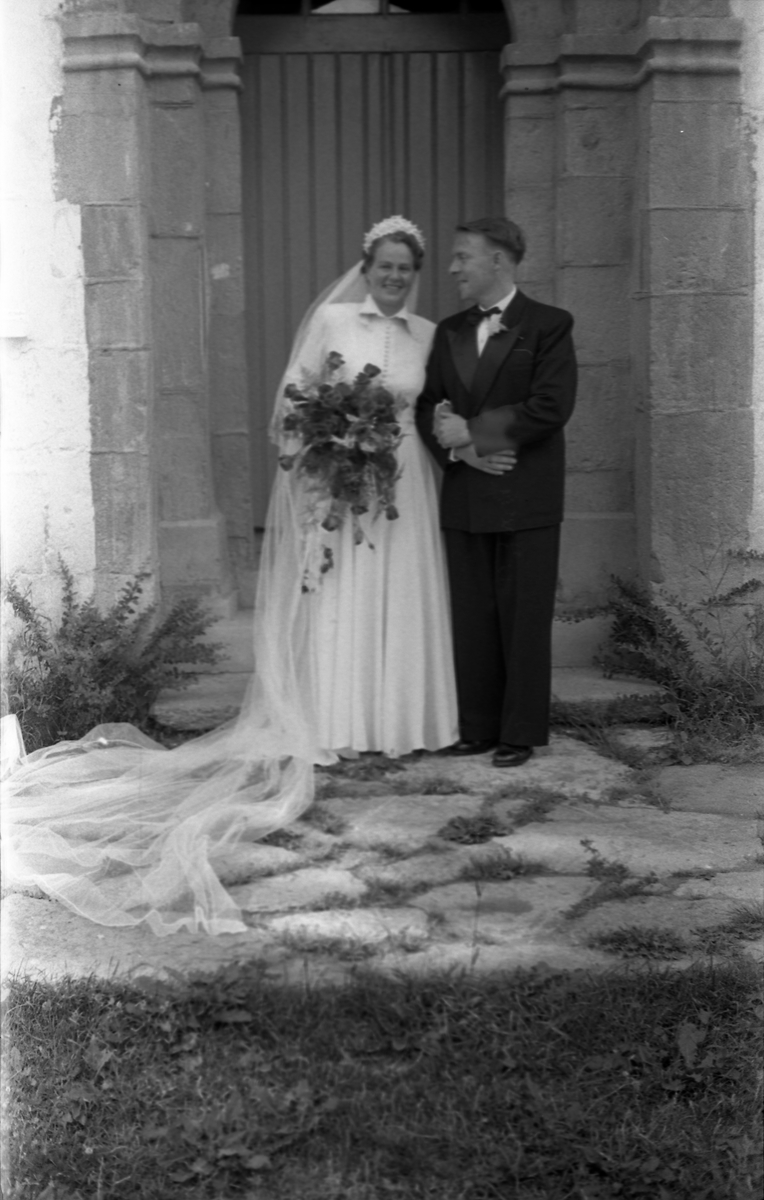 Brudeparet Else Rustad og Edvard Narum fotografert foran inngangen til Hoff kirke. Serie på 11 portretter, noen i helfigur, andre i halvfigur.