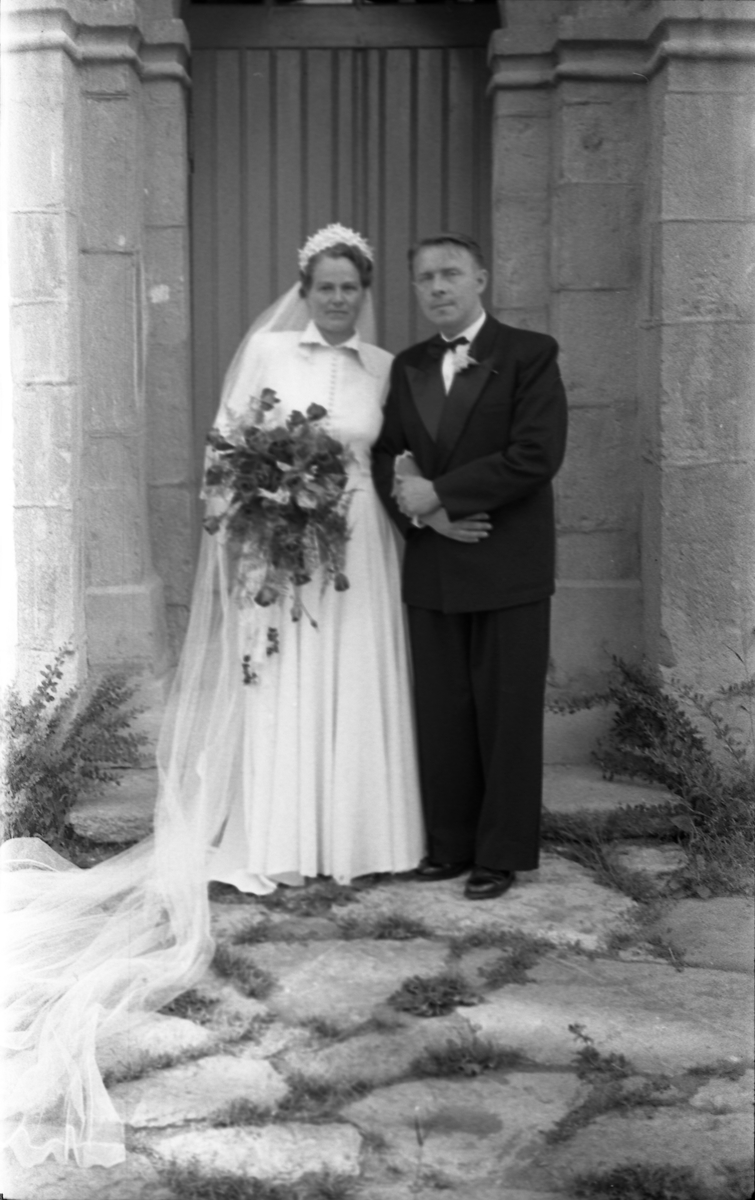 Brudeparet Else Rustad og Edvard Narum fotografert foran inngangen til Hoff kirke. Serie på 11 portretter, noen i helfigur, andre i halvfigur.