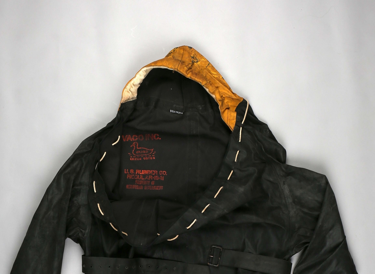 Hel overlevelsesdrakt med støvler, gul hette og belte i livet laget i sort gummi. Åpning i halsen, rundt åpning er det små maljer med tau tredd igjennom. Ved stramming blir drakten tett. Gummisøvlene er integrert i drakten og er relativt store og tunge.