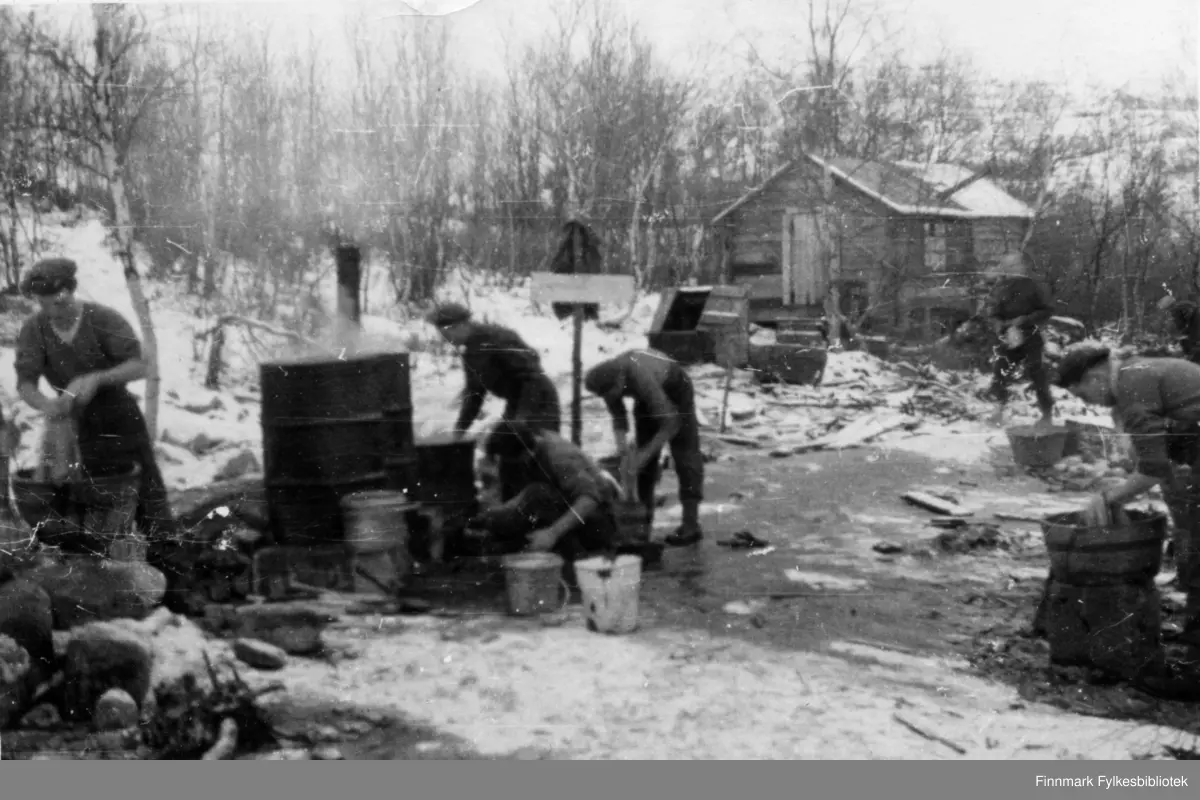 Soldatliv under frigjøringen av Finnmark. 2. Bergkompani lå i Finnmark hele vinteren 1944. Bildet viser klesvask og matlaging i svært provisoriske omgivelser. Det ser ut som det kokes vann til klesvask, en soldat til høyre og en til venstre i bildet vasker klær. 

Bildeserien "Frigjøringen av Finnmark 1944-45" viser et unikt materiale fotografert av soldater i Den Norske Brigade, 2. Bergkompani under deres oppdrag "Frigjøringen av Finnmark" som kom i stand under dekknavn "Øvelse Crofter". Fakta rundt dette bildematerialet illustrerer iflg. vår informant, George Bratli: "2.Bergkompani, tilhørende Den Norske Brigade i Skottland,  reiste fra Skottland 30. oktober 1944 med krysseren «Berwick» til Scapa Flow på Orkenøyene for å slutte seg til en større konvoi som skulle være med til Norge. Om bord på andre skip var det mange russiske krigsfanger som hadde vært på tysk side og som nå ble sendt hjem. 
2.Bergkompani forlot havn 1.november 1944 og kom til Murmansk, Sovjetunionen, 6. november 1944. 
De ble her lastet om og fraktet til Petsamo, Sovjetunionen, hvor de ankommer 11.november 1944. 
Kompaniet reiser så til Sandnes utenfor Kirkenes og blir forlagt der frem til 26.november 1944. De flytter så videre til Skipparggura. 
Den 29.november reiser deler an kompaniet til Rustefielbma og Smalfjord og noen drar opp på Ifjordfjellet. 

17. desember ankommer resten av kompaniet til Smalfjord. 30.desember blir en avdeling sendt til Hopseide og 8. januar 1945 blir noen sendt til Kunes.
Den 14. januar er kompaniet delt og ligger i Kunes, Kjæs, Børselv, Hopseide og Smalfjord.
5. februar 1945 blir 3.tropp sendt over Porsangerfjorden for å operere i Olderfjorden. Her var de i kamp og hadde tap i  Billefjord og Sortvik.
8.mars 1945 kom noen til Renøy og 12. mars kom første del av kompaniet til Brennelv.
7.mai begynte kompaniet å bygge ny kai i Hambukt.
19. mai ble de som hadde falt begravd i Lakselv.
8. juni ble kompaniet flyttet fra Brennelv til Tromsø for så å bli sendt videre til Mo I Rana 16.juni."

Nasjonalbiblioteket har et hefte fra 1983 skrevet av Krigsinvalideforbundet, med intervjuer med soldater og deres opplevelser: 
https://www.nb.no/items/5d58d366b390666f671f57078519c2c7?page=0&searchText=Det%20glemte%20kompani%20-%202.%20Bergkompani%20og%20frigj%C3%B8ringen%20av%20Finnmark

https://www.arkivverket.no/utforsk-arkivene/andre-verdenskrig/befolkede-jordhuler-kjokken-i-det-fri-og-midlertidige-begravelser-privat-bildesamling-etter-soldat-i-2.bergkompani
