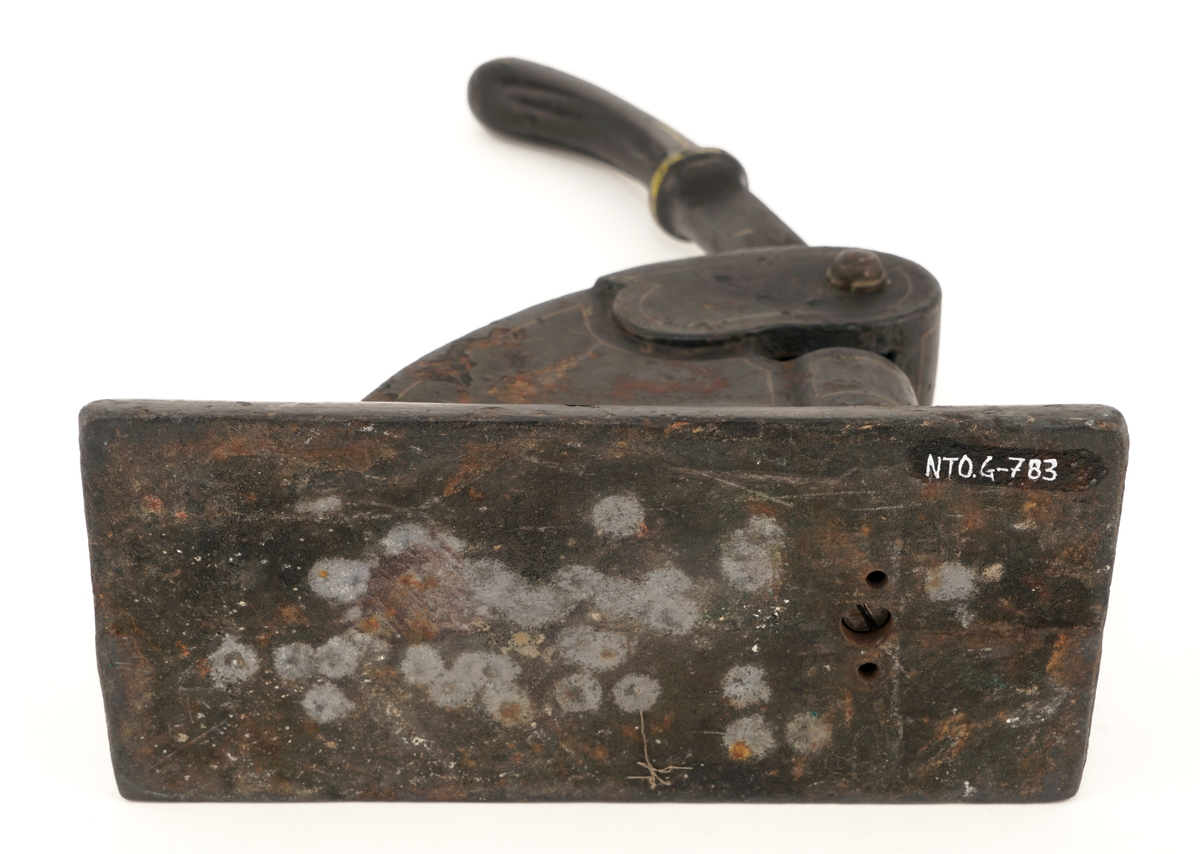 Stempelpresse av metall, sortmalt med gulfarget utsmykking. Fra Sarpsborg. Stempel: "Sarpsborg Toldoppsyn"