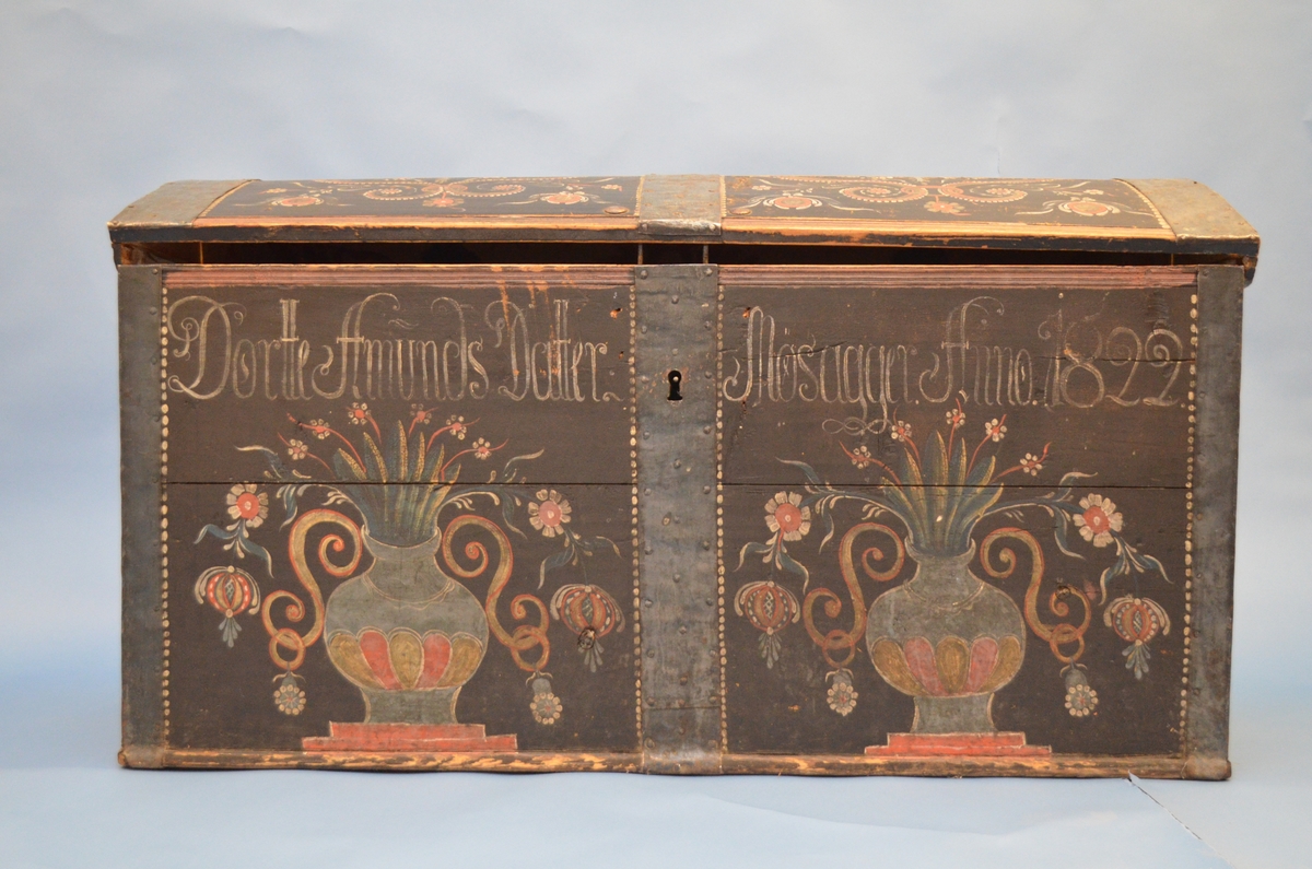 Rosemåla kiste med blomar, rankar, urner, prikkar og skrift. Påført skrift seier: Dortte Amunds Datter Mosagger Anno 1822.