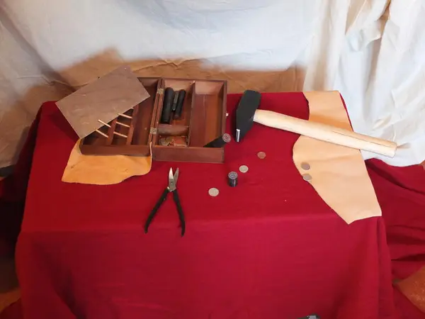 Myntslagerutstyr på et bord. Tang, hammer, skrin i tre, avbitertang, myntemner