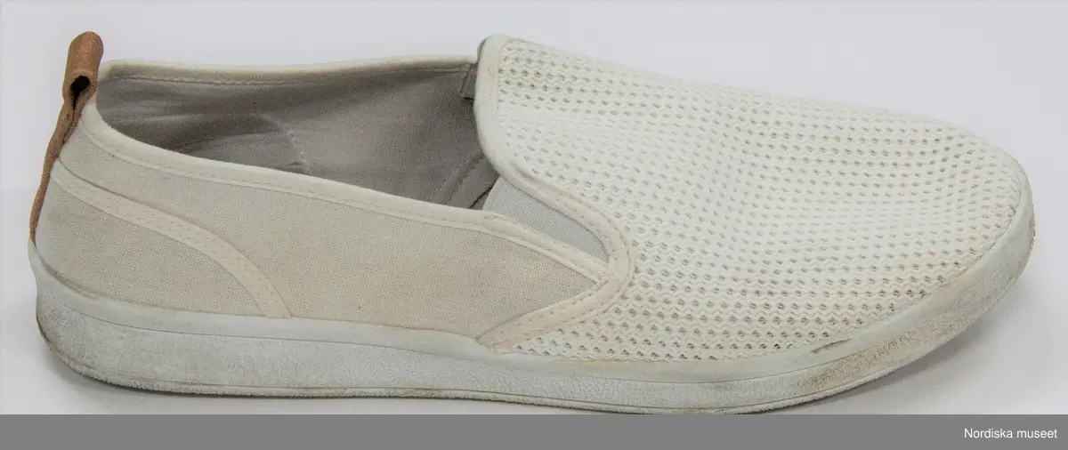 Ett par skor, vita. Sula av mjukt konstmaterial, överdel av textil (troligen blandning av bomull/syntet). Ovantill nätliknande mjukt tyg. På bakkappan brun ögla i läder. Resår vid kanten av ovandelen. Fodrad med vit textil. Innersula av vit textil med brun skoning. 
Etikett under ovandelen "42 81-305036 GOFO" och på innersulan "42 / Stepside". Under sulan storleksangivelse "42".  På innersulan på den högra skon rester kvar efter prislapp med text "Skopunkten...".
/Leif Wallin 2017-07-13