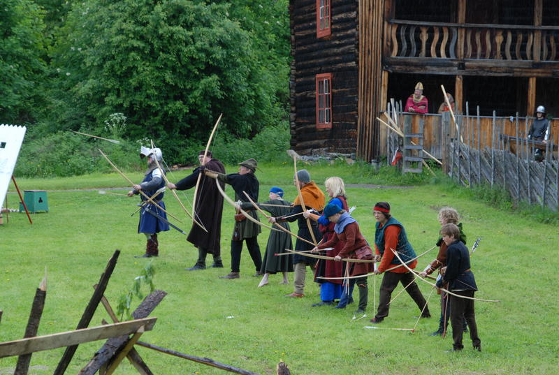 En linje med historiske bueskyttere. Alle med langbuer