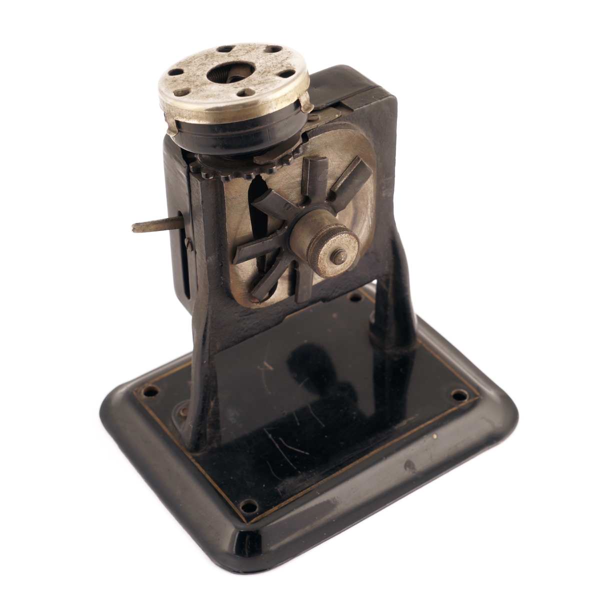 Blyantspisseapparat av  sortlakkert metall med dreiet håndtak i tre.