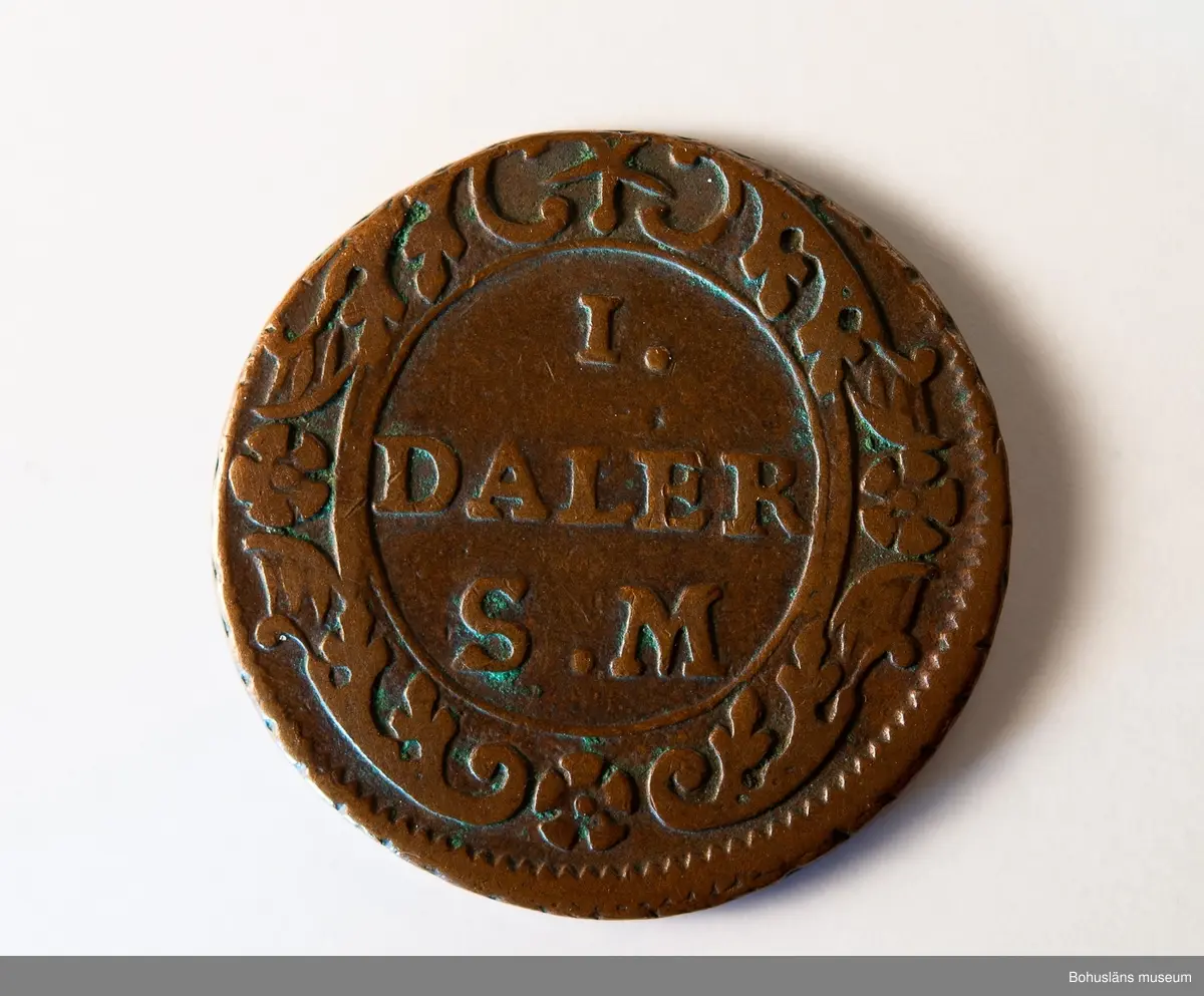1 daler silvermynt 1718, "PHOEBVS", koppar, Stockholm.
Mynt präglat under Karl XII:s regeringstid.

Åtsidan: 
Frånsidan: I DALER S.M. på tre rader.
Myntets ytterrand refflad, vinkelrätt.

Material: koppar med tvångsvärde 1 daler silvermynt.

Karl XII 1682 - 1718, kung av Sverige 1697-1718.
Förvärvsdatum okänt.