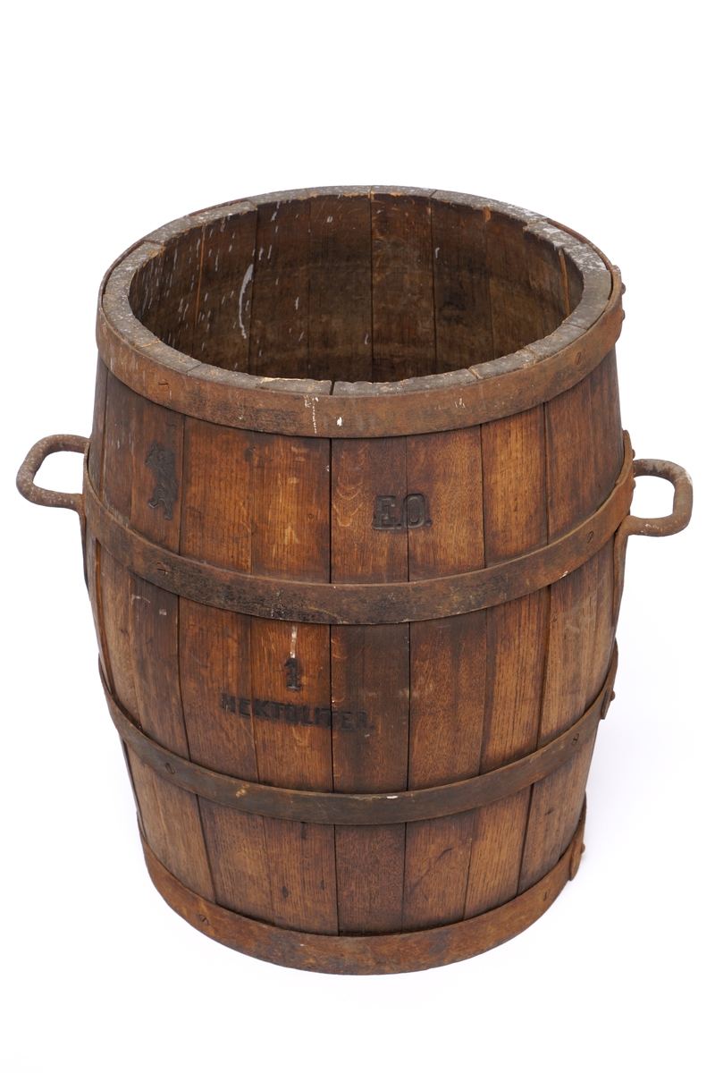 Tretønne (hektolitermål) med 2 bærehanker av metall,.Tønnen er utvendig forsynt med fire metallringer.