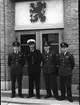 F6 Karlsborg 1954. Divisionschefen kapten Sven Alm (vit uniformsmössa) omgiven av 3 officerare ur Royal Air Force 94 squadronen. Bilden tagen vid ingången till matsalen. Albumet är en del av en donation från Karl-Axel Hansson, Karlsborg. Förteckning över hela donationen finns i albumet samt som Word-dokument.