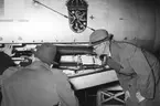 F6 Karlsborg 1954. Häradshövding Odencrantz till höger, studerar A29 vapen. Albumet är en del av en donation från Karl-Axel Hansson, Karlsborg. Förteckning över hela donationen finns i albumet samt som Word-dokument.