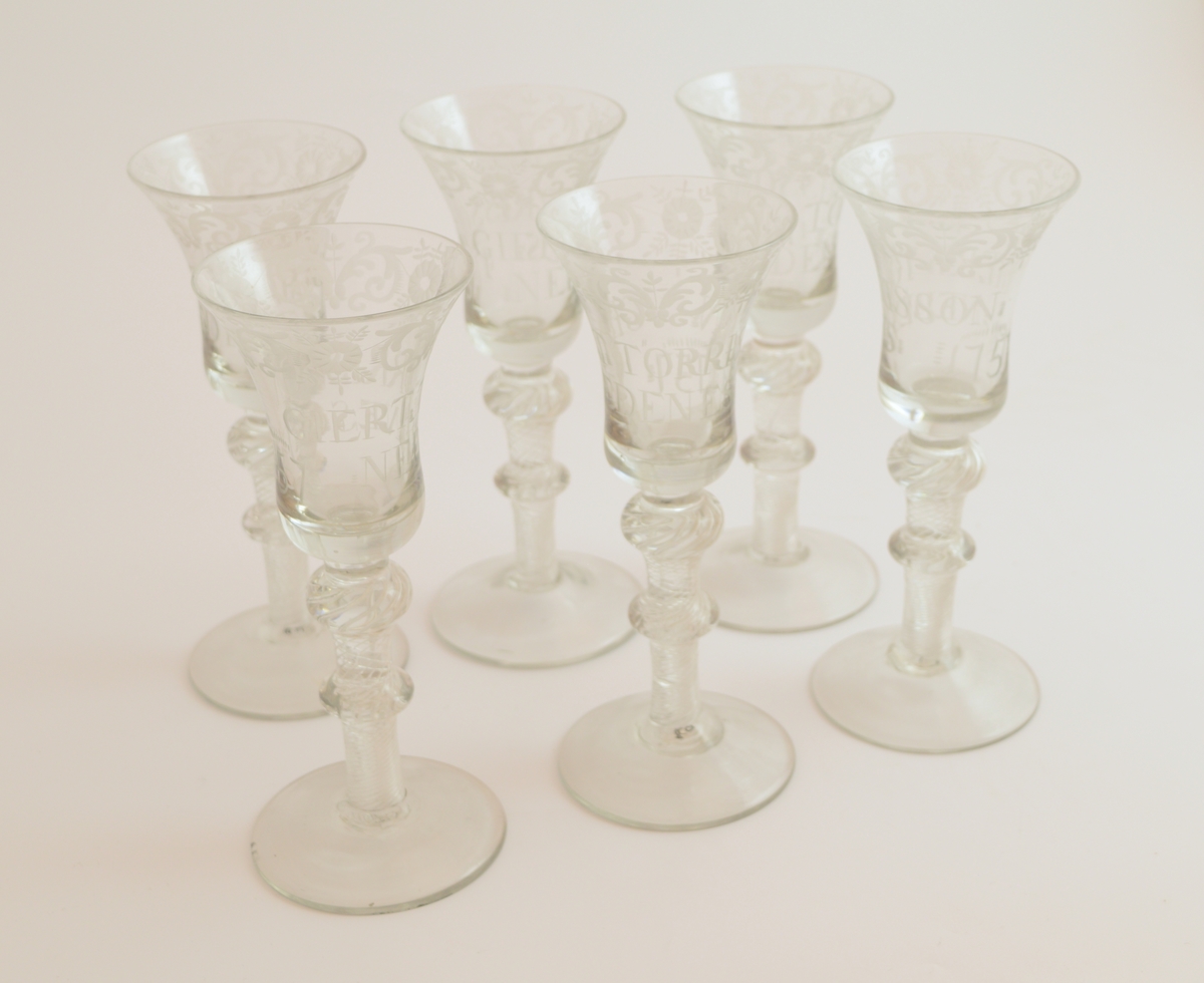 Seks glass. Rund fotplate, to runde former på stettet Klokken er smalnende midt på glasset og videst langs munningsranden.