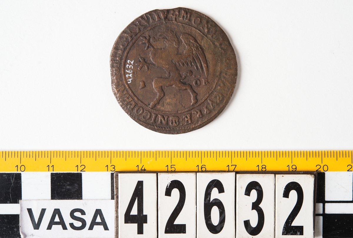 1 öre
Runt mynt
Åtsidan: mitt på myntet det svenska riksvapnet, svagt synligt.
Omskriften med Gustav Adolfs regent titlar, svagt synlig.
Ocentrerad prägling.
Frånsidan: en grip i vänsterprofil. Till vänster om gripen siffran 1, till höger versalerna ÖR.
Omskriften på latin med bland annat präglingsåret i romerska siffror, 1627, är delvis läslig.
Ocentrerad prägling.
Nuvarande skick: åtsidan sliten.
Vikt: 25,6 gram.

Text in English: Round coin. Denomination: 1 öre.
The obverse side has the Swedish coat-of-arms in the centre, faintly legible. The legend has the regent titles of Gustav Adolf of which the latter is faintly visible.
The coin stamp is off-centre.
The reverse shows a griffin in left profile. On the left-hand side is the numeral 1 and to the right the initials ÖR. which appear in capital letters. The legend has a Latin inscription and the year of coinage, 1627, in Roman numerals. The Latin inscription on the legend is partly visible.
The coin stamp is off-centre.
Present condition: the obverse side is worn.
Weight: 25,6 gram.