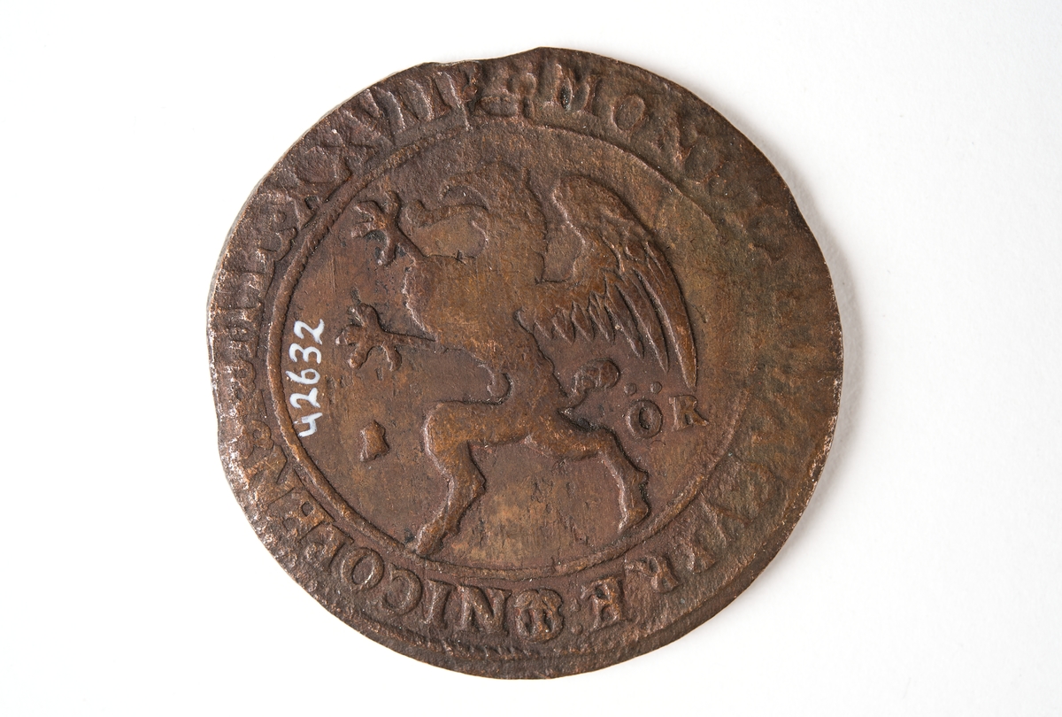 1 öre
Runt mynt
Åtsidan: mitt på myntet det svenska riksvapnet, svagt synligt.
Omskriften med Gustav Adolfs regent titlar, svagt synlig.
Ocentrerad prägling.
Frånsidan: en grip i vänsterprofil. Till vänster om gripen siffran 1, till höger versalerna ÖR.
Omskriften på latin med bland annat präglingsåret i romerska siffror, 1627, är delvis läslig.
Ocentrerad prägling.
Nuvarande skick: åtsidan sliten.
Vikt: 25,6 gram.

Text in English: Round coin. Denomination: 1 öre.
The obverse side has the Swedish coat-of-arms in the centre, faintly legible. The legend has the regent titles of Gustav Adolf of which the latter is faintly visible.
The coin stamp is off-centre.
The reverse shows a griffin in left profile. On the left-hand side is the numeral 1 and to the right the initials ÖR. which appear in capital letters. The legend has a Latin inscription and the year of coinage, 1627, in Roman numerals. The Latin inscription on the legend is partly visible.
The coin stamp is off-centre.
Present condition: the obverse side is worn.
Weight: 25,6 gram.