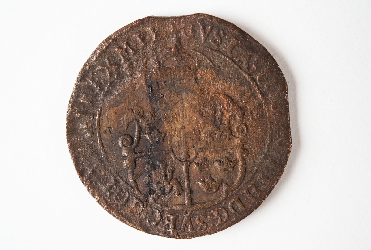 1 öre
Runt mynt
Åtsidan: mitt på myntet det svenska riksvapnet, svagt synligt.
Omskriften med Gustav Adolfs regent titlar, svagt synlig.
Ocentrerad prägling.
Frånsidan: en grip i vänsterprofil. Till vänster om gripen siffran 1, till höger versalerna ÖR.
Omskriften på latin med bland annat präglingsåret i romerska siffror, 1627, är delvis läslig.
Ocentrerad prägling.
Nuvarande skick: åtsidan sliten.
Vikt: 25,6 gram.

Text in English: Round coin. Denomination: 1 öre.
The obverse side has the Swedish coat-of-arms in the centre, faintly legible. The legend has the regent titles of Gustav Adolf of which the latter is faintly visible.
The coin stamp is off-centre.
The reverse shows a griffin in left profile. On the left-hand side is the numeral 1 and to the right the initials ÖR. which appear in capital letters. The legend has a Latin inscription and the year of coinage, 1627, in Roman numerals. The Latin inscription on the legend is partly visible.
The coin stamp is off-centre.
Present condition: the obverse side is worn.
Weight: 25,6 gram.