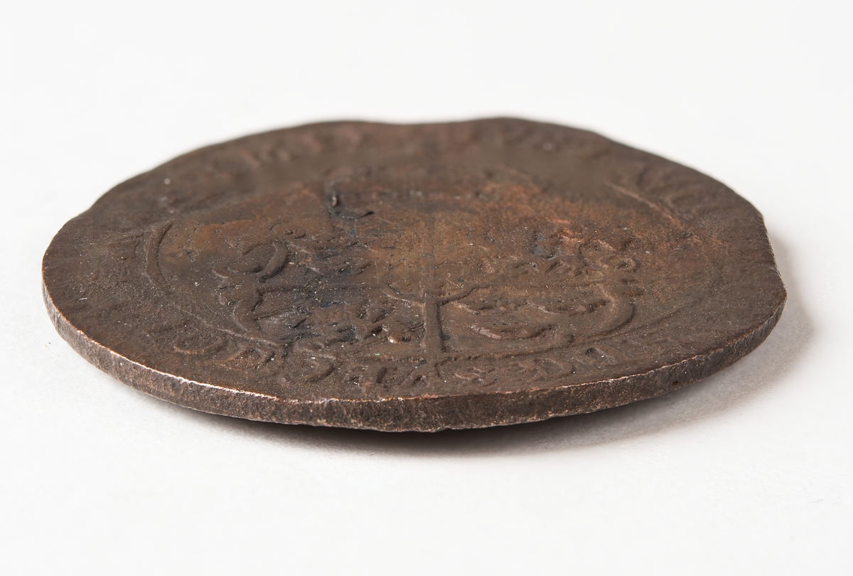 1 öre
Runt mynt
Åtsidan: mitt på myntet det svenska riksvapnet, svagt synligt.
Omskriften med Gustav Adolfs regent titlar, svagt synlig.
Ocentrerad prägling.
Frånsidan: en grip i vänsterprofil. Till vänster om gripen siffran 1, till höger versalerna ÖR.
Omskriften på latin med bland annat präglingsåret i romerska siffror, 1627, är delvis läslig.
Ocentrerad prägling.
Nuvarande skick: åtsidan sliten.
Vikt: 25,6 gram.

Text in English: Round coin. Denomination: 1 öre.
The obverse side has the Swedish coat-of-arms in the centre, faintly legible. The legend has the regent titles of Gustav Adolf of which the latter is faintly visible.
The coin stamp is off-centre.
The reverse shows a griffin in left profile. On the left-hand side is the numeral 1 and to the right the initials ÖR. which appear in capital letters. The legend has a Latin inscription and the year of coinage, 1627, in Roman numerals. The Latin inscription on the legend is partly visible.
The coin stamp is off-centre.
Present condition: the obverse side is worn.
Weight: 25,6 gram.