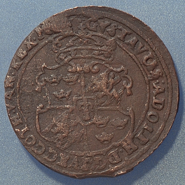 1 öre
Runt mynt.
Åtsidan: mitt på myntet det svenska riksvapnet, svagt och delvis synligt.
Omskriften, med Gustav Adolfs titlar på latin, är till största delen oläslig fullt läslig.
Ocentrerad prägling.
Frånsidan: två korsade pilar under en krona, svagt delvis synliga.
Till vänster höger om pilarna siffran 1, till höger versalerna ÖR, svagt delvis synliga. Omskriften på latin, med bland annat präglingsåret 1628, är till största delen delvis läslig delvis oläslig.
Ocentrerad prägling.
Nuvarande skick: bägge sidor slitna.  åtsidan sliten  frånsidan sliten.   jack  valsklump   korroderat   krackelerat
Vikt: 27,1 gram.