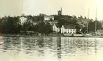 Från vänster Värdshuset, mjölnarbostaden Stjärnan, Väderkvarnen samt de båda Stenhuset. Vy från Farstaviken.