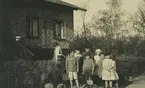 Gruppfoto utanför Franska byggena. Målar-pelle bodde under en period i huset.
Personer: H Bergschöld, Helge Johansson, Edvin Lowndes, Åke Nordqvist, Sigrid Andersson, Berta Lowndes, Margit Andersson, Berta Andersson.