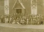 Gruppfoto. Missionsförsamlingen framför sitt här ganska nya hus, byggt 1901.
Personer: okända