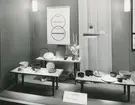 Interiörbild. Utställning av hushållsporslin i stengods från Gustavsbergs Fabriker. Arrangerad av Landsföreningen Dansk Konsthantverk, Charlottenborg, Danmark. Lokal okänd.