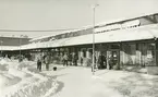 Exteriörbild. Vintervy över del av Gustavsbergs centrum. Systembolaget i fokus.
Personer: Okända personer.