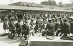 Exteriörbild.Musikunderhållning av orkester i samband med invigningen den 24 april 1964.av det nybyggda Domus, Gustavsbergs centrum.
Personer: okända