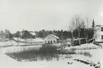 Exteriör. Tvättstugan vid Bagarns träsk, Gustavsberg. Riven i samband med byggnationen av Runda huset 1953 strax intill. T.v. Klubbhuset och t.h. Bageriet.